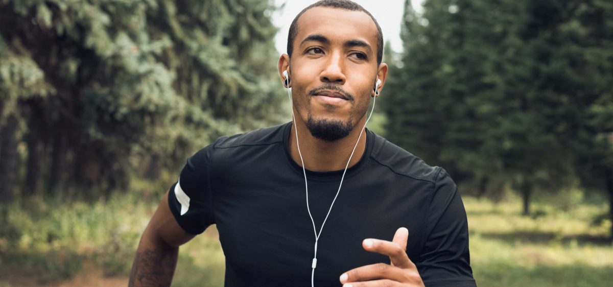 A man runs with earbuds